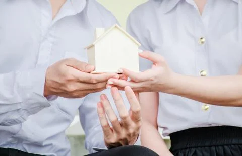 Closeup hands of an couple students holding a little house together Stock Photos