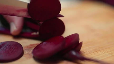 Closeup of hands cutting fresh beetroots on a cutting board.  Stock Footage 310203780