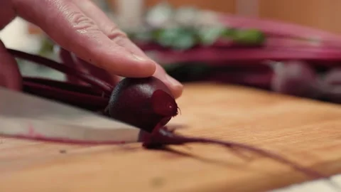 Closeup of hands cutting fresh beetroots on a cutting board.  Video stock 310203914