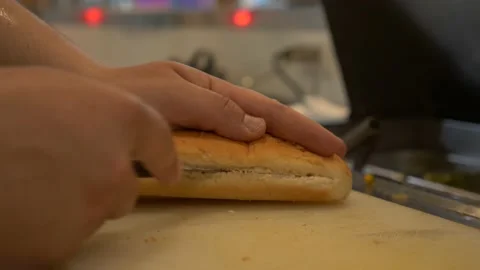 Closeup of hands cutting a hotdog bread with knife in a kitchen 4K 60fps Stock Footage 196988654