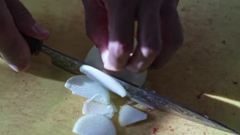 Closeup hands cutting onion into half rings on kitchen board Video stock 316203482