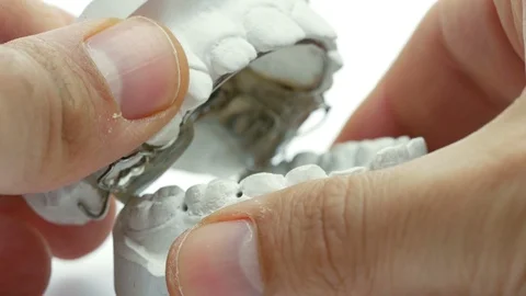 Closeup hands of dental techinician working with kid orthodontic appliance	 Stock Footage 122952054