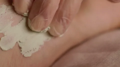 Closeup of hands doing procedure to legs with cram in a beauty salon Video stock 52512343