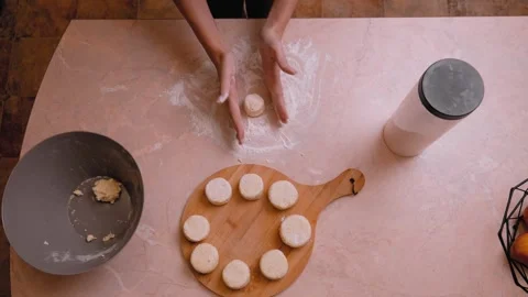 Closeup of hands dusting flour and shaping dough into small buns on work surface Видео 331152688