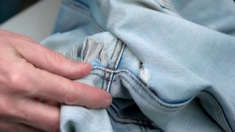 Closeup hands exploring holes on jeans. tailor checks holes rubbed between legs. Stock Footage 242701520