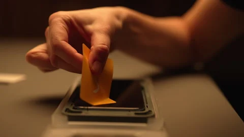 Closeup hands of female technician using sticky dust absorber to meticulously Stock Footage 302564805