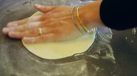 Closeup of hands flattening dough on table with flour Stock Footage 40732297