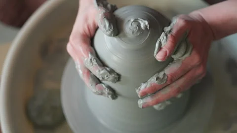 Closeup hands forming clay swirl with fingertips, concentric rings, wet slip Stock Footage 342282280