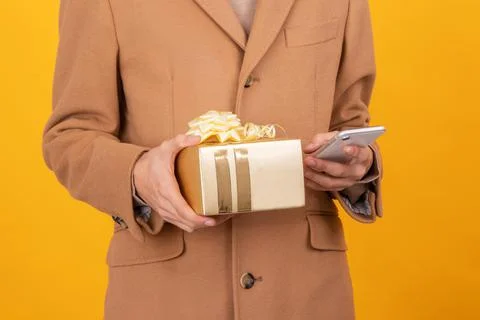 Closeup of hands with gift box and mobile phone Stock Photos