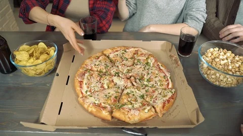 Closeup hands of a group of people taking slices of pizza from a corton box. Stock Footage 125608460