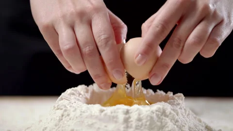 Closeup Hands Holding A Cracked Egg, Breaking An Egg That Falls On A Pile Flour Stock Footage 170238765