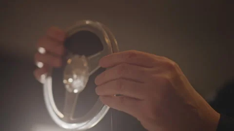 Closeup hands holding empty reel in warm studio light archivist inspects spool Stock Footage 346550292