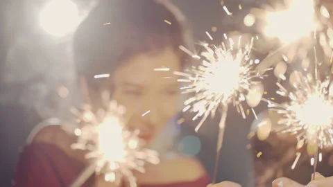 Closeup of hands lighting sparklers. Multiracial young people celebrate New YEAR Stock Footage 220090415