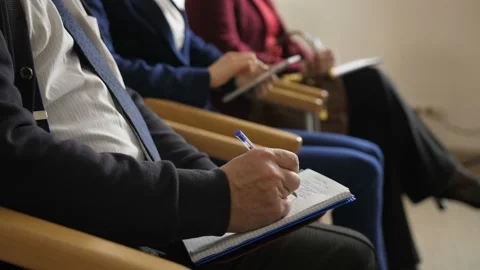 Closeup hands of listeners noting during training Stock Footage 108008213
