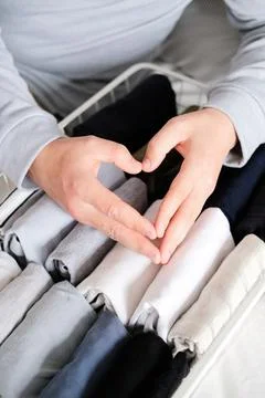 Closeup of hands of an man tidy up things in mesh storage containers. Vertical Stock Photos