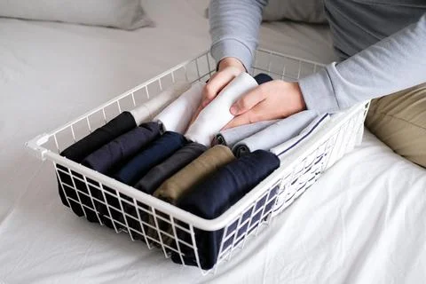 Closeup of hands of an man tidy up things in mesh storage containers. Vertical Stock Photos
