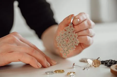 Closeup hands of master holding tatted earrings jewelry Stock Photos