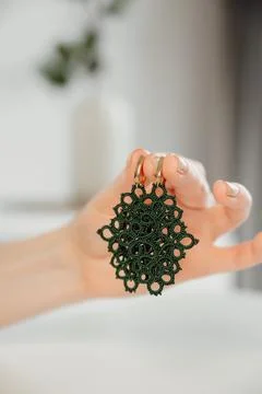Closeup hands of master holding tatted earrings jewelry. vertical banner, hobby Stock Photos