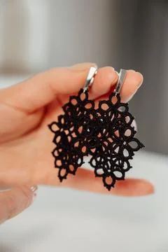 Closeup hands of master holding tatted earrings jewelry. vertical banner, hobby Stock Photos