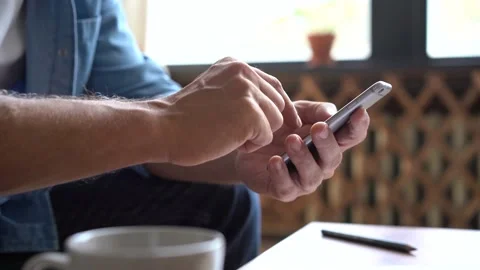 Closeup hands of mature man using smartphone, typing message on mobile phone. Stockbeeldmateriaal 141184359