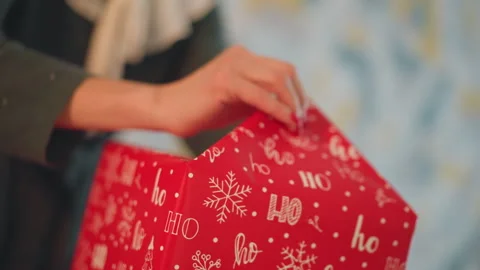 Closeup of hands meticulously wrapping gift inside cozy room. Intimate shot Stock Footage 345168267