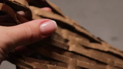 Closeup of hands moving through thick perforated kraft paper used for protective Stock Footage 327682904
