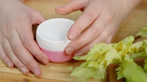 Closeup hands open jar take cream at table with greens Stock Footage 101234037