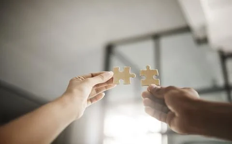 Closeup hands of partners in unity, planning and working on strategy puzzle Stock Photos