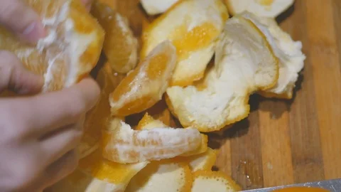 Closeup hands peeling orange fruit on kitchen board Stockbeeldmateriaal 100706796