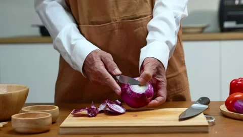Closeup of hands peeling red onion in home kitchen with knife. Food prep, c.. Stock Footage 312978719