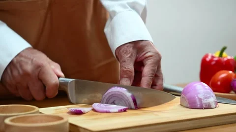 Closeup of hands peeling red onion in home kitchen with knife. Food prep, c.. Stock Footage 312978745