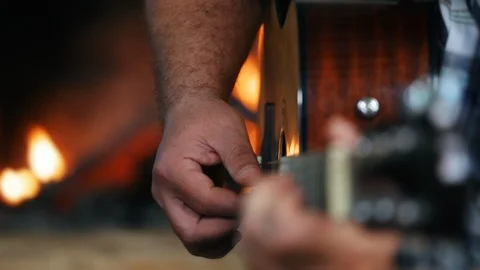 Closeup of hands playing guitar in front of a fireplace side view Stock Footage 108088056