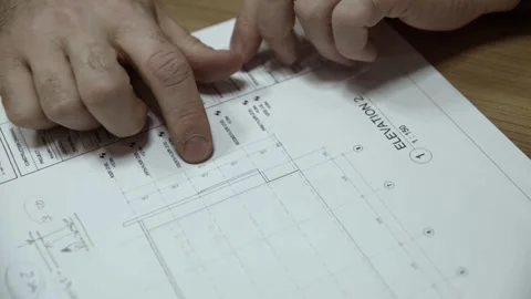 Closeup of hands pointing on building's plan drawings businessman and architects Video stock 280867090