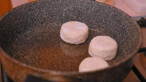 Closeup of hands pressing edges into dough discs over hot skillet Stock Footage 330022542