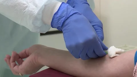 Closeup of the hands pull the needle out of the vein and bandage my hand Stock Footage 132318595