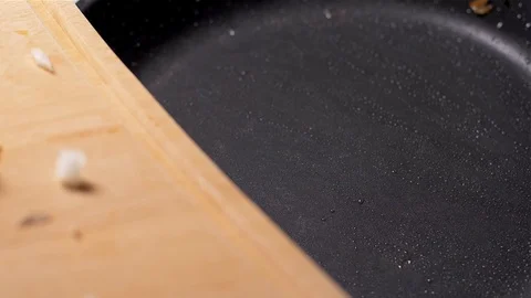 Closeup of  hands putting chopped onion on hot frying pan Stock Footage 103574117