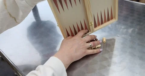 Closeup of hands setting up game of backgammon and chess on table Stock Footage 292756055