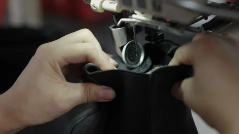 Closeup of Hands Sewing Black Shoe Upper with Industrial Machine in Workshop Stock Footage 341668216