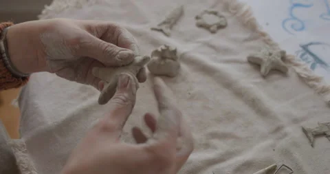 Closeup of hands shaping and holding a clay star during the crafting process Stock Footage 301617482