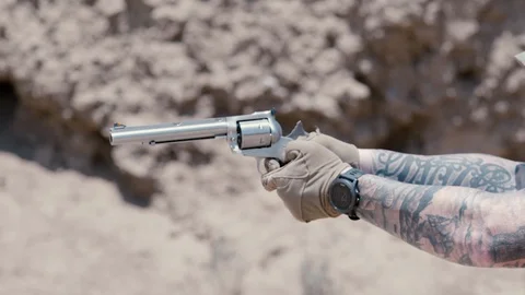 Closeup of hands shooting small silver gun, day Stock Footage 101759730