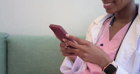 Closeup hands showing clinician tapping pink phone and checking smartwatch on Stock Footage 341089983