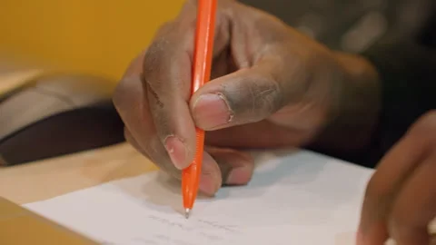 Closeup hands signing document with orange pen, laptop and mouse nearby, seal Stock Footage 333183492