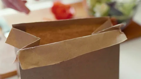 Closeup of hands slicing bell pepper and putting a waste into a paper trash bag. 库存影片 305847810
