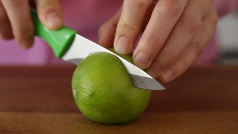 Closeup of Hands Slicing a Lime with a Knife Stock Footage 91799852