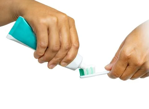 Closeup on hands squeezing toothpaste on toothbrush Stock Photos