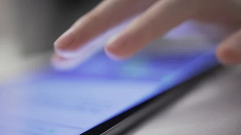 Closeup hands with tablet. She is scrolling the screen while searching for Stock Footage 120107137