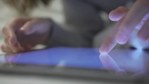 Closeup hands with tablet. She is scrolling the screen while searching for Stock-Footage 120107359