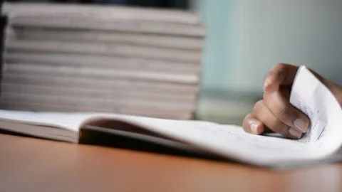 Closeup of hands turning pages and moving a finger along the lines while Stock Footage 106938026