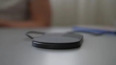 Closeup hands of unrecognizable man putting smartphone on wireless charging pad Stock Footage 297631562