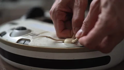 Closeup hands of unrecognizable person removing worn out side brush from robotic Видео 342755924